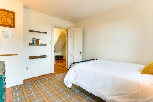 a bedroom with a white bed and a staircase at Walkable Location Historic Home in Charles Town! in Charles Town