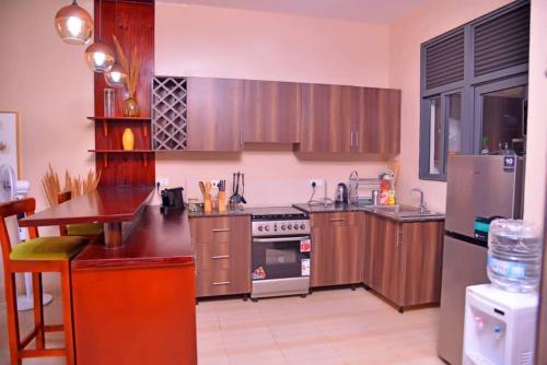 a kitchen with wooden cabinets and a stove top oven at Betty's Apartments in Ntabwe