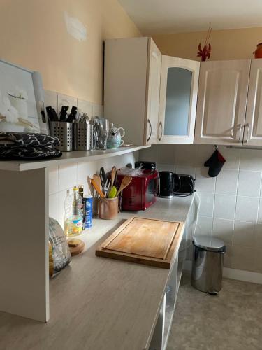 a kitchen with a wooden cutting board on a counter at Séjour à la campagne in Crévin