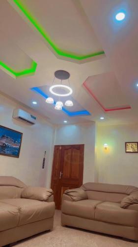 a living room with two couches and a ceiling with colored stars at House of David Apartment and Suites in Cotonou