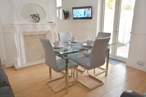 a dining room with a glass table and chairs at Contractor Lodge- 6 Bedrooms-Sleeps 10-Free Parking- Weekly Stays in Hull