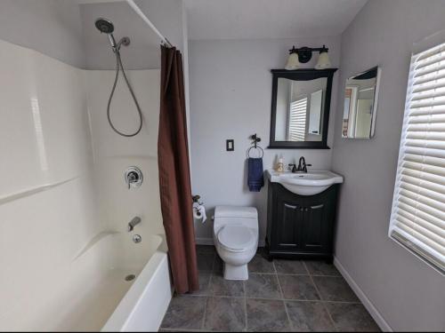 une salle de bain avec un lavabo, des toilettes et une baignoire dans l'établissement Catch on the Canal - Waterfront Getaway Near Casino, Dining & Entertainment, à Standish