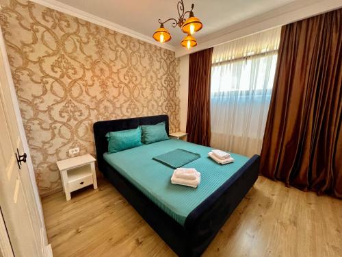 a bedroom with a bed with two towels on it at Catedrala Blue in Constanţa