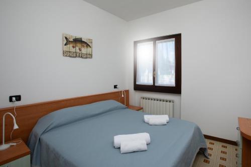 Un dormitorio con una cama con dos toallas encima. en PARISI - Sirmione Punta Gro', en Sirmione