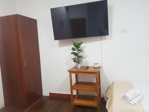 a flat screen tv hanging on a wall with a table at HOTEL EL SOL dEL GALERAS in Pasto