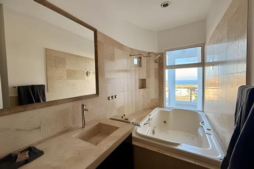 a bathroom with a tub and a sink and a window at Vista Colorada in El Bedito