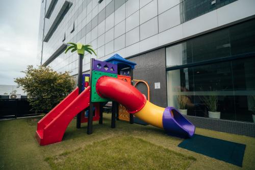 a playground with a slide in front of a building at Hilton Garden Inn Praia Brava in Itajaí