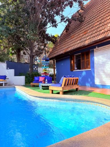 a swimming pool with a blue house and a blue building at MAKTVB Costanera - Hostal Boutique in Santiago