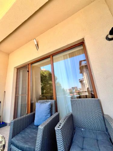 a balcony with two wicker chairs and a blue pillow at Catedrala Blue in Constanţa