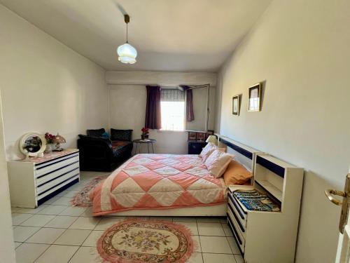 a bedroom with a bed and a couch and a window at Luxury appartement centre ville Fes - French Touch in Fès