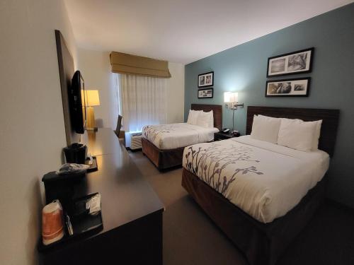 a hotel room with two beds and a television at Sleep Inn & Suites O'Fallon MO - Technology Drive in O'Fallon