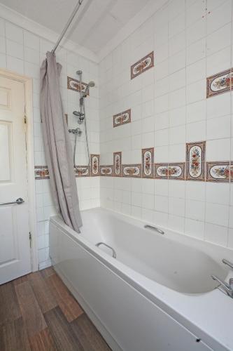 a white tub in a bathroom with a shower at Contractor Lodge- 6 Bedrooms-Sleeps 10-Free Parking- Weekly Stays in Hull