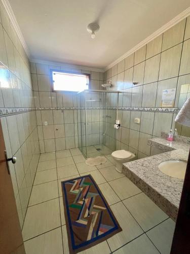 a bathroom with a glass shower and a toilet at Hotel Vila Solar in Limeira