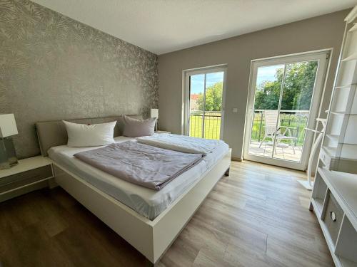 a bedroom with a bed and a large window at Ferienwohnung Emil - barrierefrei mit Fahrstuhl und Carport in ruhiger Altstadtlage von Ballenstedt in Ballenstedt