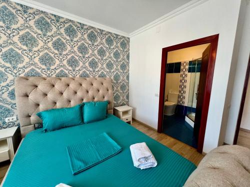 a bedroom with a large bed with blue sheets and a mirror at Catedrala Blue in Constanţa