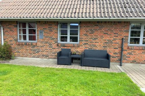two chairs sitting on a patio in front of a brick house at 80011-Vemb-Harpotvej-84 in Skalstrup