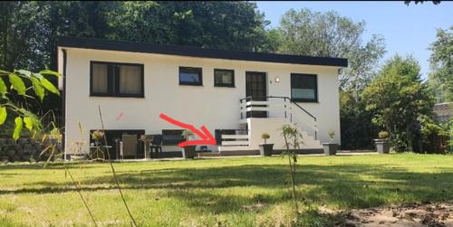 a small white house with a grass yard at Apartment im Grünen bis 7 Personen in Buchholz in der Nordheide