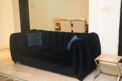 a black couch in a living room with a table at Cremyark Homes in Benin City