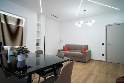 a living room with a dining table and a couch at Eschilo - Cairoli Apartments in Gela