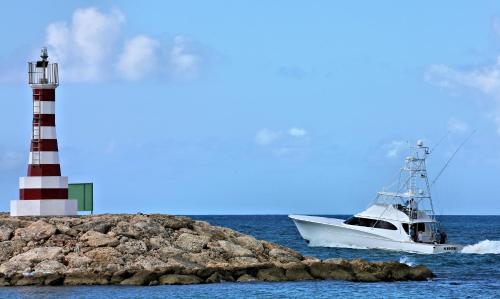 a boat in the water next to a lighthouse at Casa de Campo Resort & Villas in La Romana