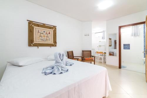 a white room with a bed with a towel on it at Aldeia Da Lagoinha in Ubatuba