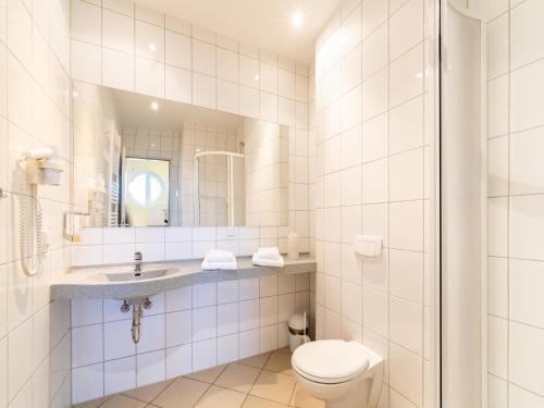 ein Badezimmer mit Toilette, Waschbecken und Spiegel in der Unterkunft Ideale Familienwohnung in der Natur in Granzow