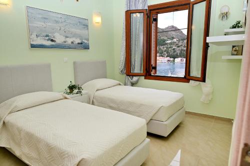 twee bedden in een kamer met een raam bij Voula's Traditional House in Meyisti