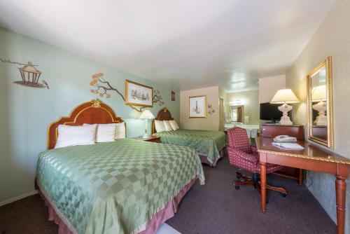a hotel room with two beds and a desk at Americas Best Value Inn - Legend's Inn in Junction