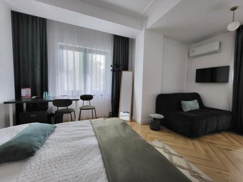 a bedroom with a bed and a desk and a chair at New Times Stay in Bucharest