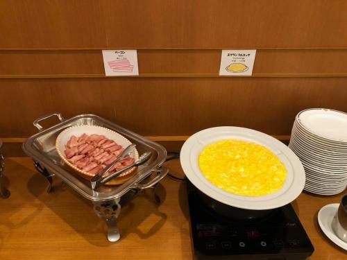a stove with a pan of food and a bowl of eggs at Smile Hotel Tokushima - Vacation STAY 10491v in Tokushima