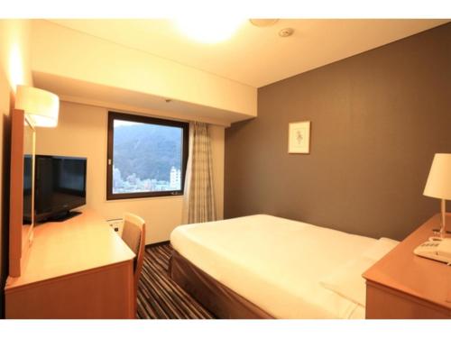 a hotel room with a bed and a window at Smile Hotel Tokushima - Vacation STAY 10498v in Tokushima