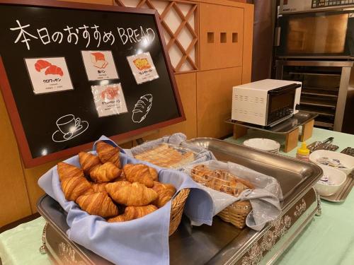 a table with a tray of bread and pastries at Smile Hotel Tokushima - Vacation STAY 10491v in Tokushima