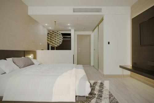 a bedroom with a large white bed and a television at AC Hotel by Marriott Georgetown Guyana in Georgetown