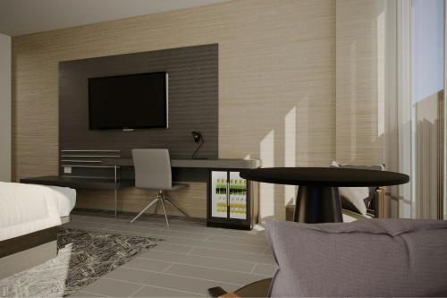 a bedroom with a desk and a tv on a wall at AC Hotel by Marriott Georgetown Guyana in Georgetown
