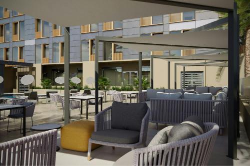 a patio with chairs and tables and a building at AC Hotel by Marriott Georgetown Guyana in Georgetown