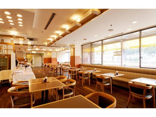 a restaurant with tables and chairs and windows at Smile Hotel Tokushima - Vacation STAY 10510v in Tokushima