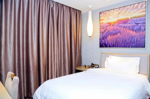 a bedroom with a white bed and a curtain at Lavande Hotel Baiyun International Airport Branch in Guangzhou