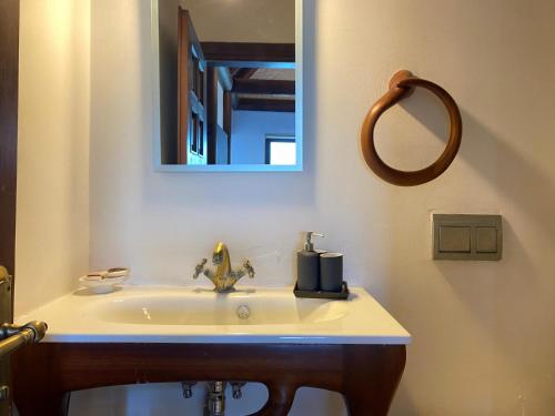 a bathroom with a sink with a mirror and a mirror at Charming 1BR Stone House with Lake View in Bogazici