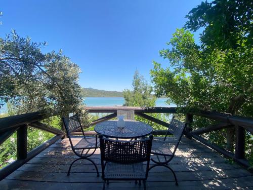 a table and chairs on a deck with a view of the water at Charming 1BR Stone House with Lake View in Bogazici
