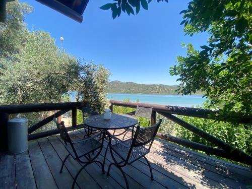 a table and chairs on a deck with a view of the water at Charming 1BR Stone House with Lake View in Bogazici