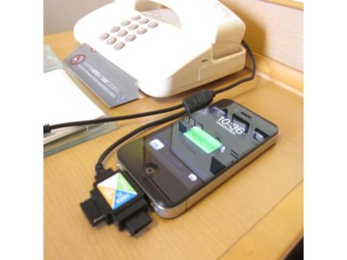 a cell phone hooked up to a charger on a table at Smile Hotel Tokushima - Vacation STAY 10502v in Tokushima