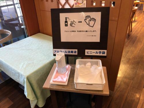 a table with a sign next to a bed at Smile Hotel Tokushima - Vacation STAY 10502v in Tokushima