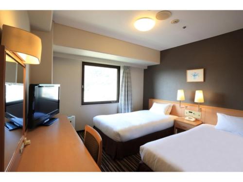 a hotel room with two beds and a television at Smile Hotel Tokushima - Vacation STAY 10502v in Tokushima