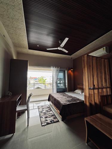 a bedroom with a bed and a ceiling fan at Hepah Homestay in Dibrugarh