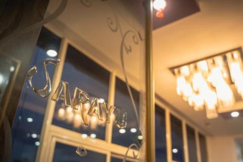 a reflection of a sign in the window of a store at Hotel Sarayu Hassan in Hassan