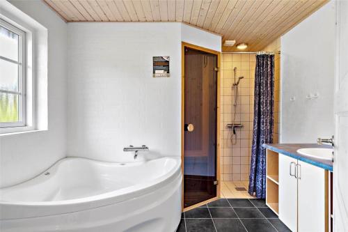 un bagno con una vasca bianca e un lavandino di 60857-Ulfborg-Illeborgvej-38 a Fjand Gårde