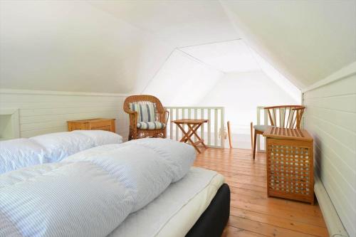 a room with two beds and chairs in a attic at 30358-Ulfborg-Bynkevej-367 in Vang