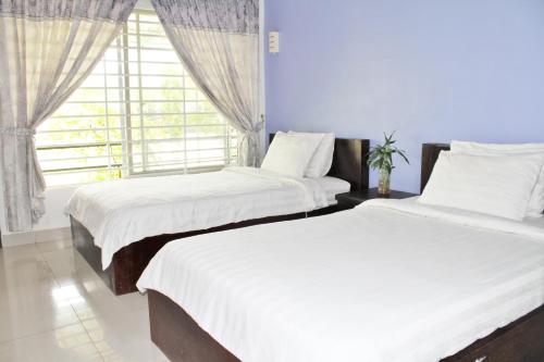 two beds in a room with a window at My Parents Guesthouse in Kampot