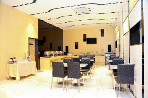 a dining room with tables and chairs and a bar at Lavande Hotel Baiyun International Airport Branch in Guangzhou