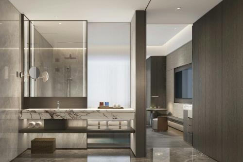 a bathroom with a sink and a large mirror at Courtyard by Marriott Zhuhai in Zhuhai